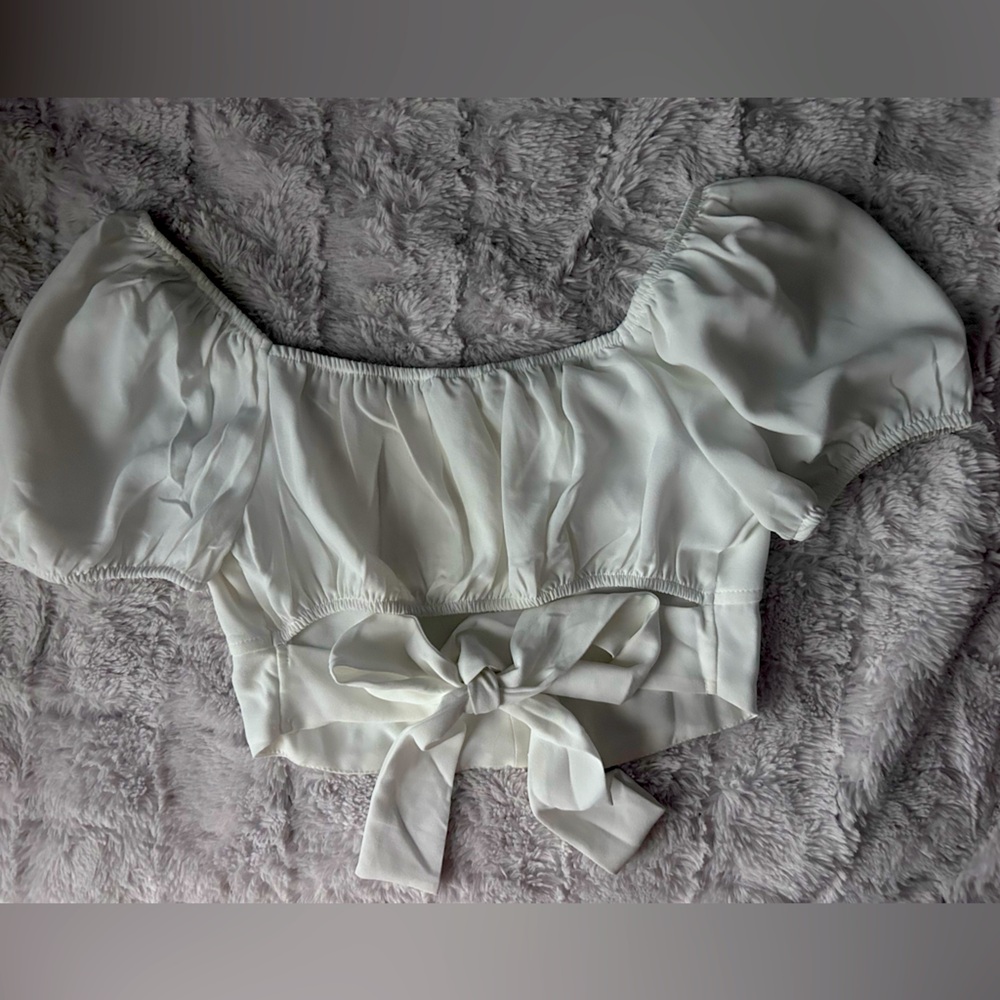 white blouse, sleeves can be worn off the shoulder, bow that ties in the back.